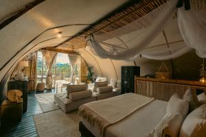 a bedroom with a large bed and a living room at Atma Villas Hotel Boutique Guatapé in Guatapé