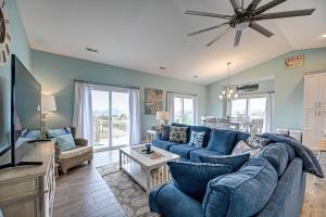 a living room with a blue couch and a tv at Ocean View - Just Steps from Oceanfront - 2 Full Width Sun Decks - 3 King Suites in North Topsail Beach