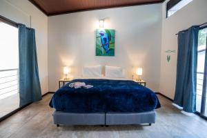 a bedroom with a large bed with two lamps at Nereus in Puerto Jiménez +35 photos