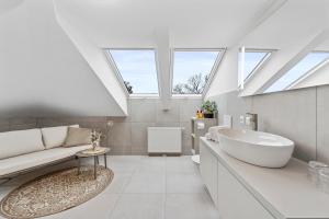 Un baño con una gran bañera blanca y un lavabo. en VIVE Hotel & Restaurant Vienna, en Viena