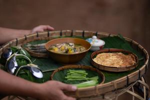 a table topped with food and vegetables on a table at Pang Ma - O rice terrace นาขั้นบันไดบ้านปางมะโอ in Ban Pha Mon