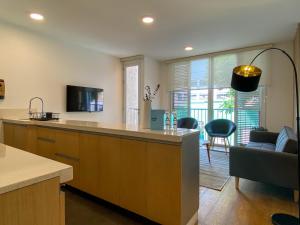 a kitchen with a counter and a living room at Duplex with Balcony in Barranco in Lima