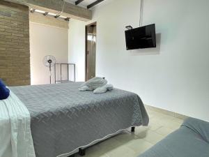 a bedroom with a bed and a flat screen tv at M1145 Aparta Loft in Pereira