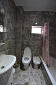 a bathroom with a sink and a toilet and a bath tub at Aeropuerto Ezeiza Nuevo Descanso in Monte Grande