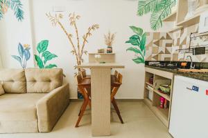 a living room with a table and a couch at Apê aconchegante a 50m do mar - Maracaípe in Porto De Galinhas