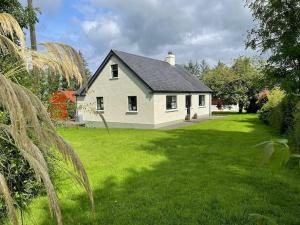 a white house in a yard with green grass at Littlemount Farm Cottage in Brookeborough
