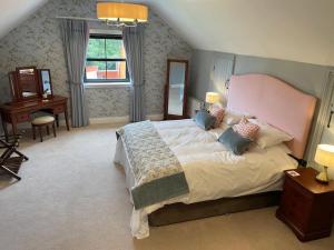 a bedroom with a large bed and a desk at Littlemount Farm Cottage in Brookeborough