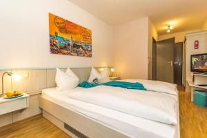 a bedroom with a large white bed in a room at Hotel AMENITY in Munich
