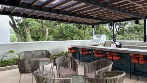 a patio with a bar with chairs and a grill at Luxury apartment 10 min to Airport Be Cariari Condo #402 in La Asunción