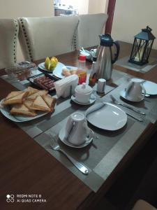 a table with plates and utensils and food on it at ZOE HOMES Home Away From Home For Cozy And Modern Stay in Nairobi