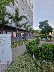 a sign in front of a building with trees and plants at Moov 916 Studio Mooca in Sao Paulo