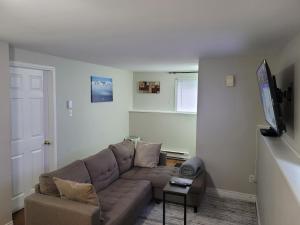 Una sala de estar con un sofá y un televisor de pantalla plana. en Full 1-bedroom apartment, en St. John's
