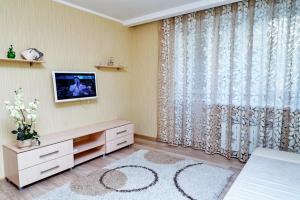 uma sala de estar com televisão e uma grande janela em Apartament Volga River em Saratov