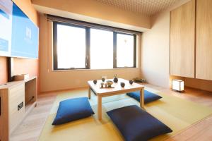 a living room with a table and a large window at MONday Apart Premium Ginza Shintomicho in Tokyo