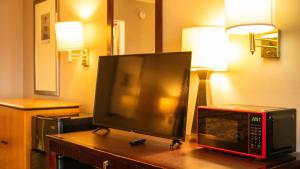 TV y microondas en una mesa en una habitación en Executive Inn Yanceyville, en Yanceyville 8 fotos más