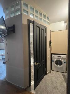 Una puerta a un lavadero con lavadora. en Apartment tbilisi central, en Tiflis