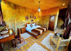 a bedroom with a bed in a stone walled room at Riad Chay & Boutique in Ouarzazate