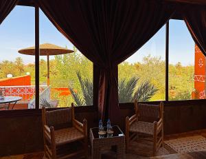 a room with two chairs and a large window at Riad Chay & Boutique in Ouarzazate