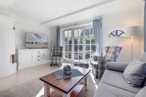 a living room with a couch and chairs and a table at Fries Huis in Wenningstedt