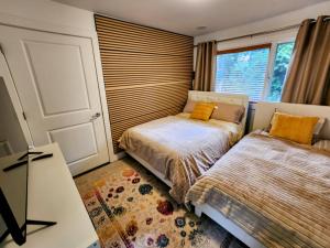 a bedroom with two beds and a window at 2BD Guest Suite Sleeps 6 Near Downtown & Beach in West Vancouver +38 photos