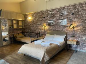Un dormitorio con una pared de ladrillo y una cama. en Apartment tbilisi central, en Tiflis