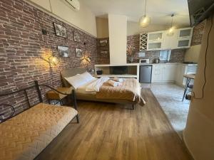 una habitación con una cama y una pared de ladrillo en Apartment tbilisi central, en Tiflis