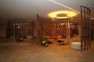 a lobby with chairs and a plant in a building at Grand Hotel&Casino Vía Dorada in Pachuca de Soto