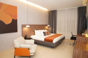 a hotel room with a bed and a chair at Grand Hotel&Casino Vía Dorada in Pachuca de Soto