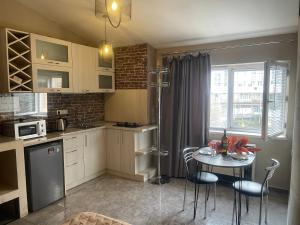 una cocina con mesa y sillas y una ventana en Apartment tbilisi central, en Tiflis 18 fotos más