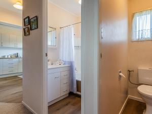 a bathroom with a toilet and a sink at Central Riverside Retreat - Taupo Holiday Home in Taupo +17 photos