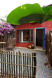 a red house with a blue door and a fence at Casa Da Ro in Ilhabela