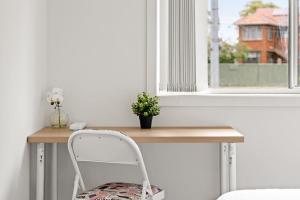 einen Schreibtisch mit einem Stuhl vor einem Fenster in der Unterkunft Comfy Double Room in Panania - Nearby Stations & Shops - Shared Bathroom in Panania