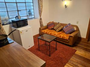Una sala de estar con un sofá y un televisor. en Departamentos Cusco, en Cusco