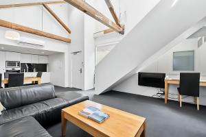 a living room with a couch and a table at Gibson Mill waterfront loft apartment - 304 in Hobart
