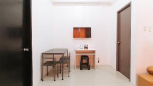 a small kitchen with a table and chairs at RedDoorz @ Jardin LRT Tayuman Manila in Manila