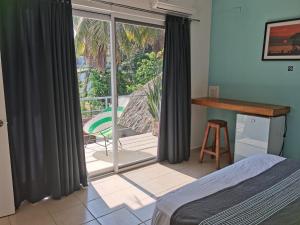 a bedroom with a window with a view of a patio at Casa De La Palmera in Brisas de Zicatela