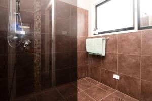 a bathroom with a shower with brown tile at The Wetlands in Warrnambool +33 photos