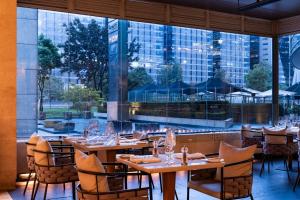 a restaurant with tables and chairs in front of a large window at Bogotá Marriott Hotel in Bogotá