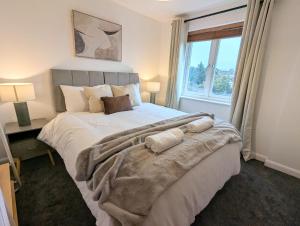 ein Schlafzimmer mit einem großen Bett mit einem großen Fenster in der Unterkunft 36 Handley's Elite Apartment 2Bed Flat CityCenter in Hemel Hempstead