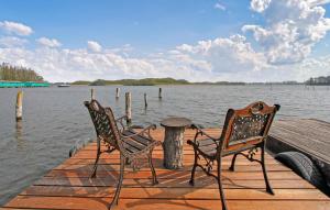 two chairs and a table on a dock on a lake at Ferienwohnung Südmüritz in Vipperow +12 photos