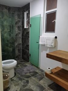 a bathroom with a toilet and a glass shower at Casa De La Palmera in Brisas de Zicatela