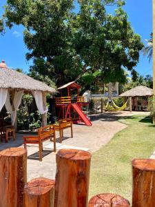 a playground with a red slide in a park at Village do Sossego in São José da Coroa Grande
