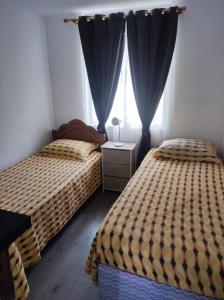una camera da letto con due letti e una finestra di Departamento La Serena, amoblado, 2 habitaciones, a una cuadra de la playa a La Serena