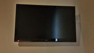a black flat screen tv hanging on a wall at Guest House Porto Clerigus in Porto