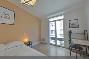 a bedroom with a bed and a desk and a window at 3 bedrooms-Very bright and spacious appt- wifi in Toulon