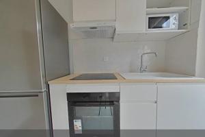 a small kitchen with a sink and a refrigerator at 3 bedrooms-Very bright and spacious appt- wifi in Toulon