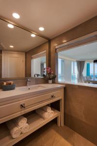 a bathroom with a sink and a large mirror at Herbert Samuel Okeanos Suites Herzilya in Herzelia 