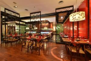 a restaurant with wooden tables and chairs in a room at Equatorial Ho Chi Minh City in Ho Chi Minh City