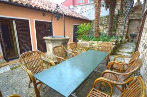 a green table and chairs in a courtyard at Holiday Home Svalba in Rovinj