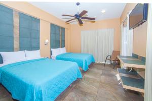 a hotel room with two beds and a ceiling fan at Hotel Nonni in Santa Cruz Huatulco